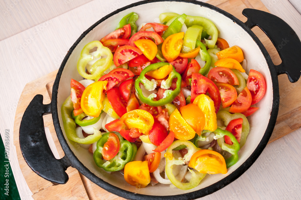 Sliced vegetables in a frying pan stand on table Sliced vegetables in a frying pan stand on table
