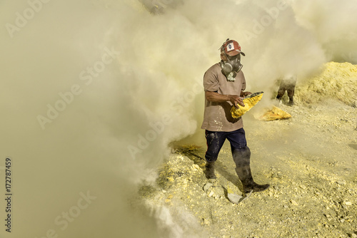 Kawah Ijen sulphur miner collecting solidified sulphur, Indonesia