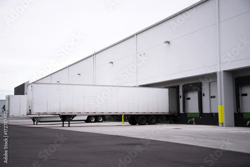 Semi trailers waiting loading and unloading in the dock of warehouse