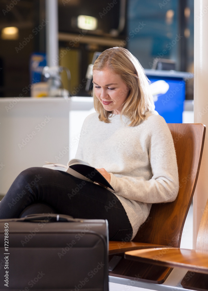 Woman Reading Book In Airport Waiting Area Woman Reading Book In Airport Waiting Area