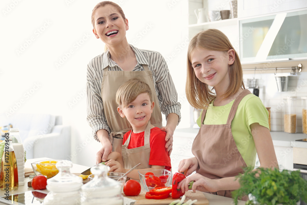 Mother and children making meal together in kitchen. Cooking classes concept Mother and children making meal together in kitchen. Cooking classes concept
