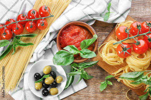 Composition with tasty tomato sauce and pasta on table