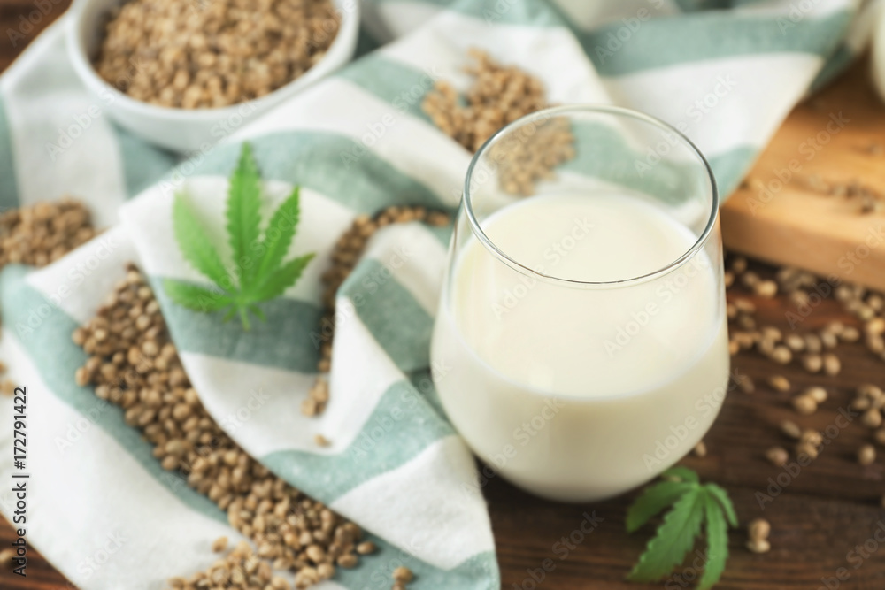 Glass with hemp milk on wooden background Glass with hemp milk on wooden background