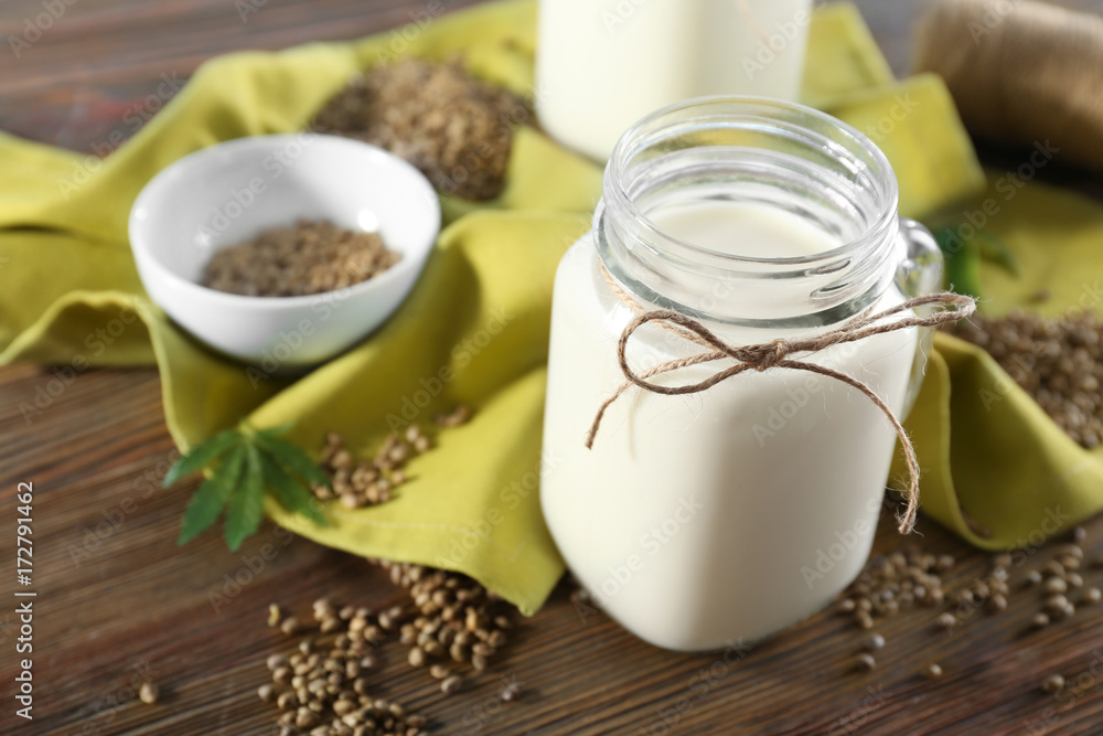 Jar with hemp milk on wooden table Jar with hemp milk on wooden table