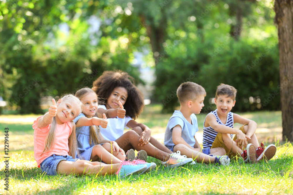 Group of children sitting on grass in park Group of children sitting on grass in park