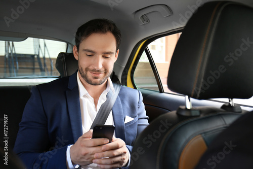 Handsome man with phone sitting in taxi car © Africa Studio