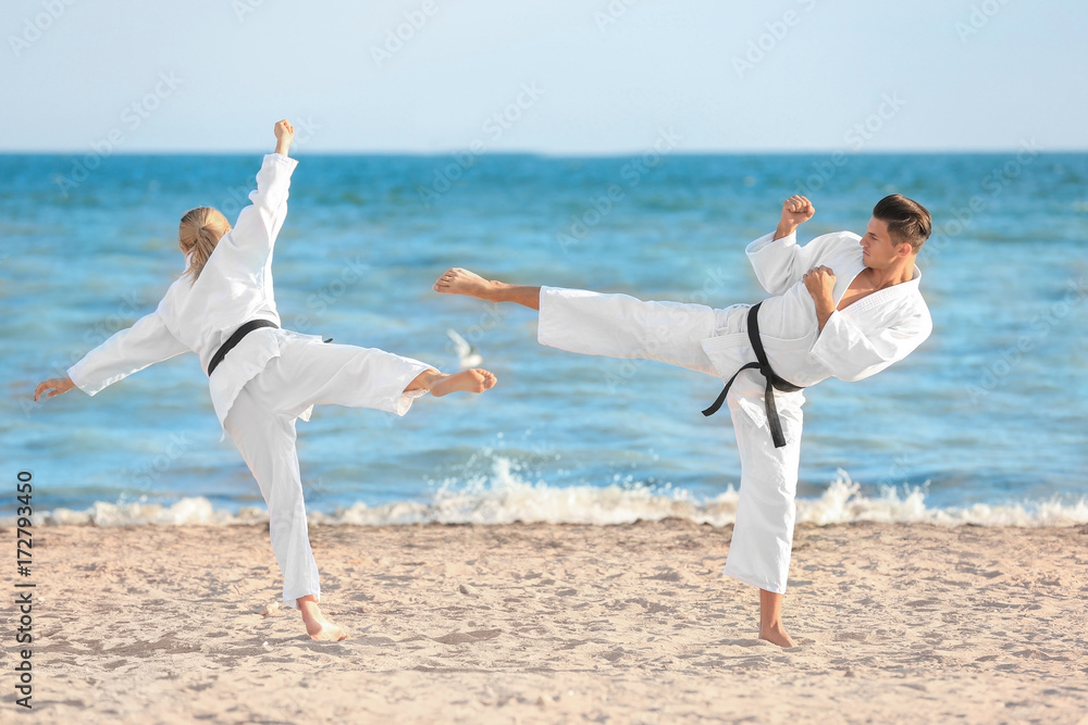 Young man and woman practicing karate outdoors Young man and woman practicing karate outdoors
