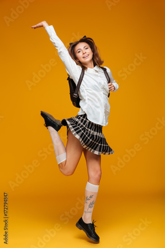 Obraz na plátne Full length portrait of a happy teenage schoolgirl in uniform