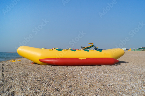 Yellow and red banana as a beach entertainment stands on the shore