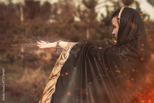 the witch in a black cloak uses magic