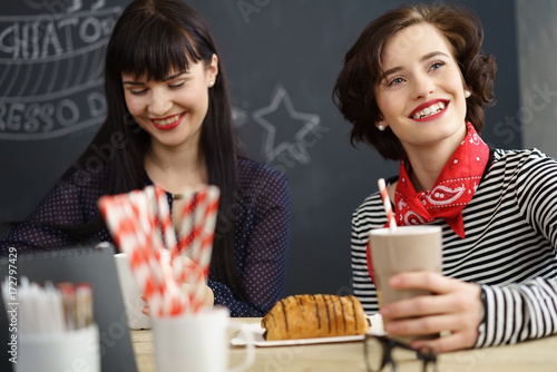 lachende freundinnen sitzen in einem café
