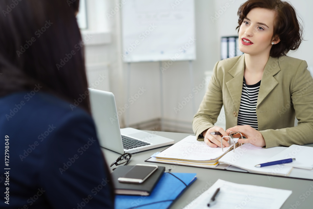frauen unterhalten sich im büro am schreibtisch frauen unterhalten sich im büro am schreibtisch