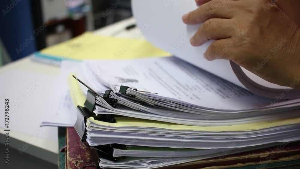 Officer Businessman searching data in Stacks of papers files on work desk in office, business report paper or piles of unfinished documents notation with clips on offices desk, Business concept