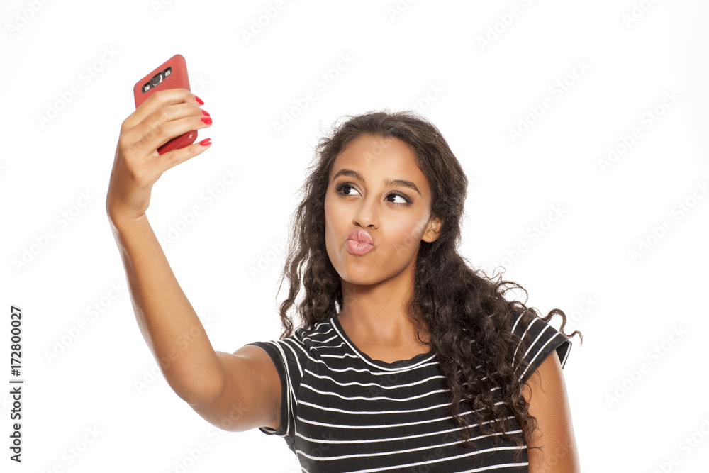 Young and beautiful dark skinned girl taking a selfies with her smartphone Young and beautiful dark skinned girl taking a selfies with her smartphone
