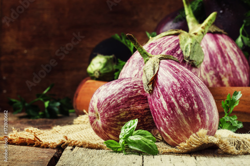 Raw striped eggplants, rustic style, selective focus