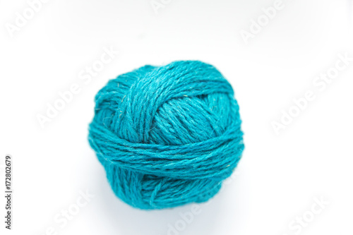 Small colorful ball of wool yarn on a white background. Hand craft supplies.
