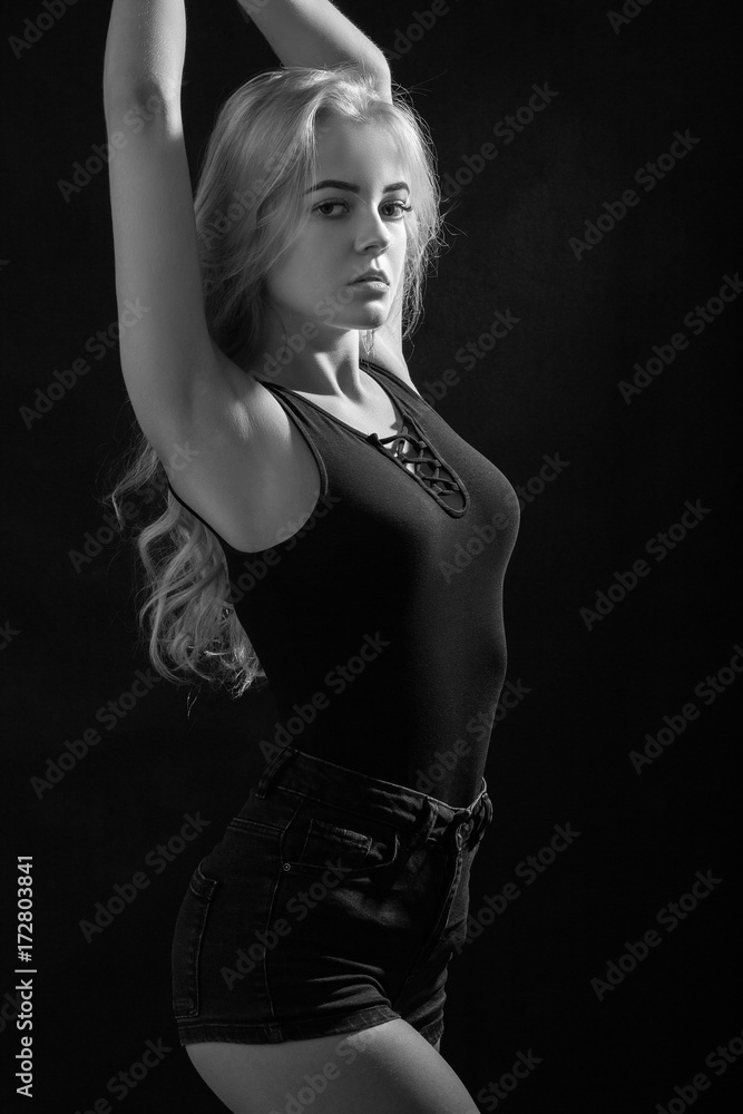 beautiful young woman show her slim body on black background, monochrome beautiful young woman show her slim body on black background, monochrome