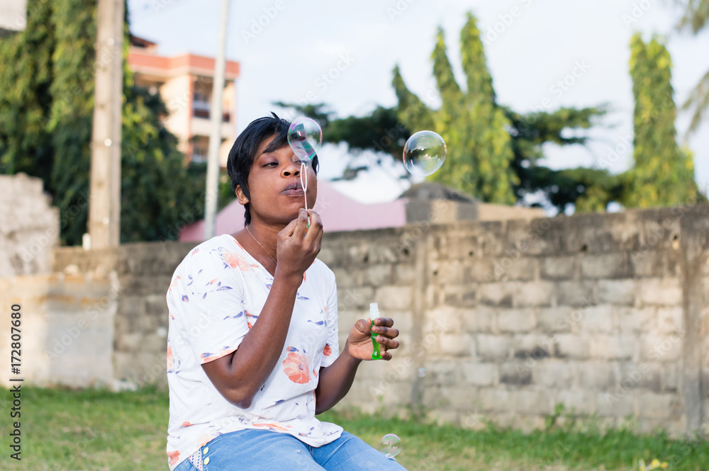 Fototapeta premium girl blowing soap bubbles in the park