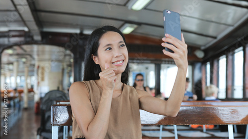 Photography Woman taking selfie with cellphone on ferry in Hong Kong