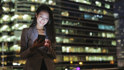 Photography Business woman sending text message on cellphone at night