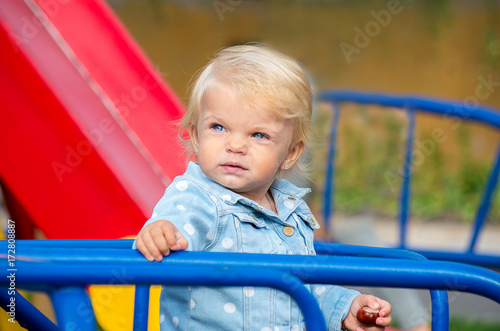 Portrait of a blonde girl with blue eyes on a playground © pyansetia2008