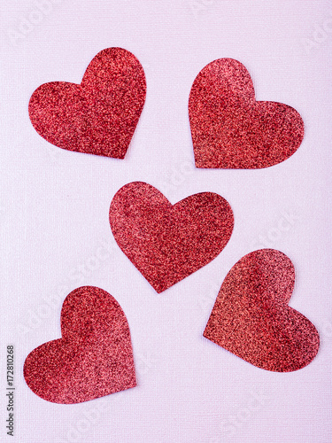 röda glitter hjärtan mot rosa pappers bakgrund photo