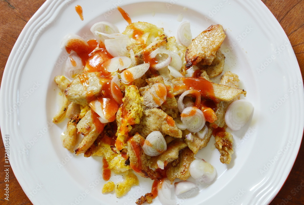 fried chicken with egg topping slice shallot and dressing chili sauce on dish