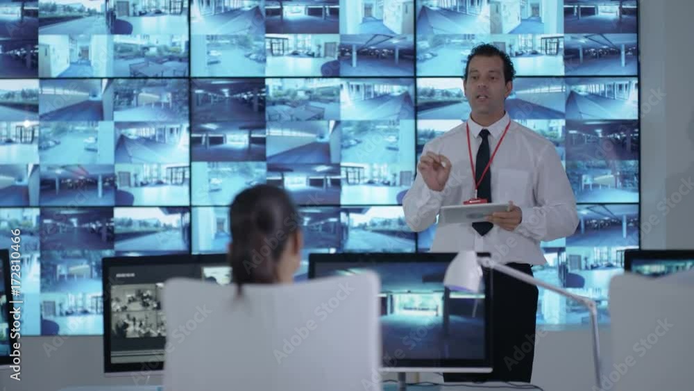 Security officer communicating with staff in observation control room Security officer communicating with staff in observation control room