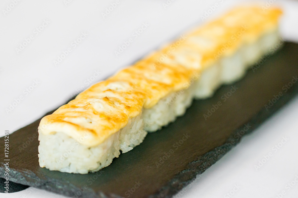 Uncut Japanese sushi roll on wooden tray Uncut Japanese sushi roll on wooden tray