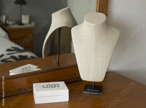 Exhibitor of jewels. Mannequin on the dresser in a room.