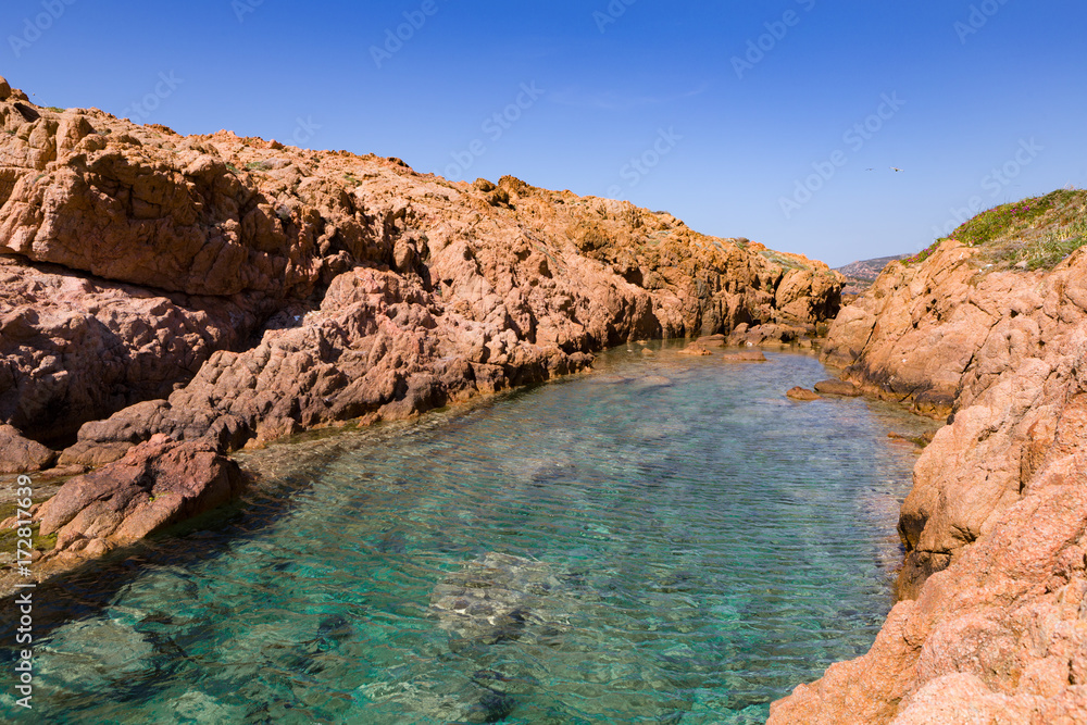 colorful rocky inlet on the coast with red rocks and turquoise water