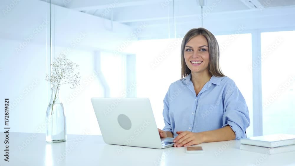 Smiling Young Woman at Work looking Toward Camera Smiling Young Woman at Work looking Toward Camera