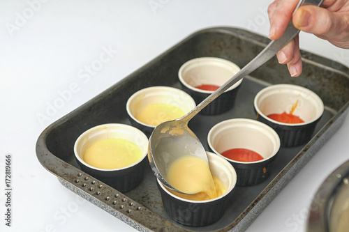 Pouring creme on the caramel in pots