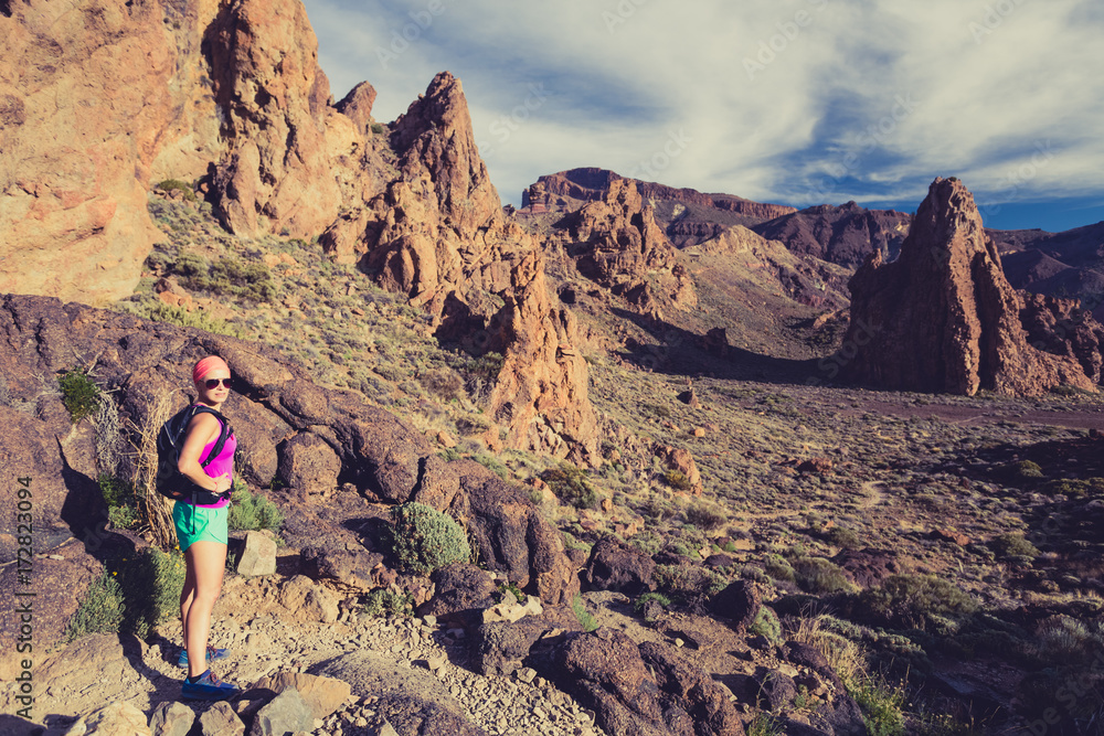 Fototapeta premium Happy girl hiker walking on mountain path, backpacker adventure