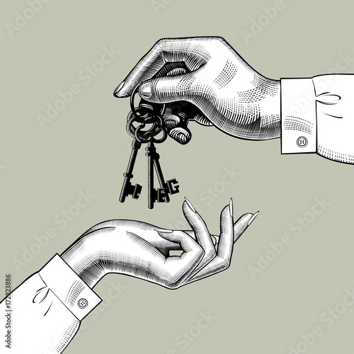 A man's hand gives the keys to a woman's hand