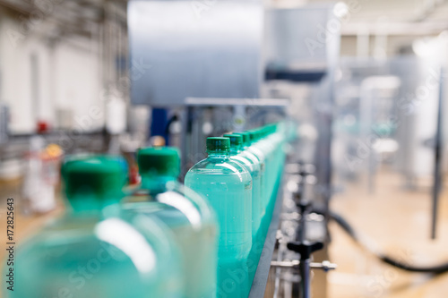 Bottling plant - Water bottling line for processing and bottling carbonated water into green bottles. Selective focus. 