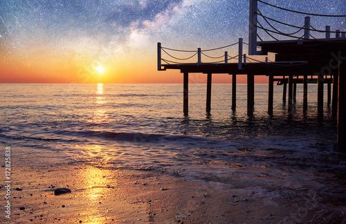 Fantastic starry sky and the Milky Way to the pier at sea, used to natural background sea. Romantic night