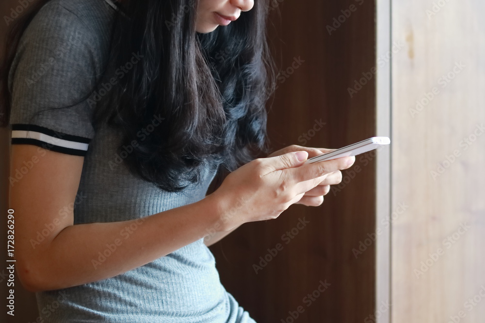 Obraz premium スマートフォンで音楽を聴く女性