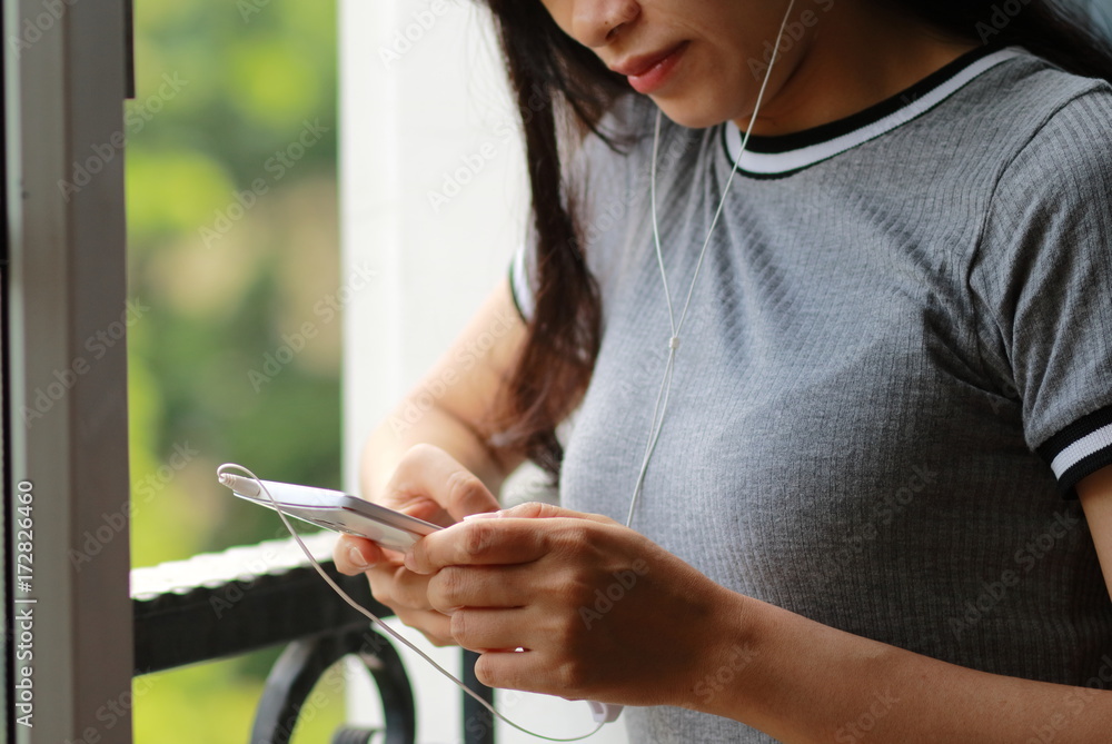 スマートフォンで音楽を聴く女性 スマートフォンで音楽を聴く女性