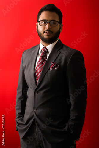 Business man in suit in front of red background © Zulqarnain