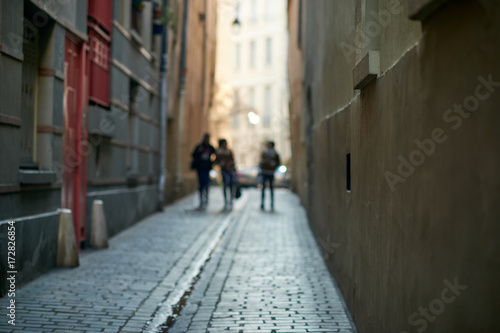 three young people on a narrow street in paris © Lari