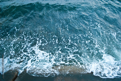 Blue sea, emerald wave beats against the shore