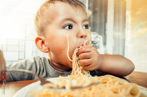 Photos Baby in the kitchen eagerly eating pasta