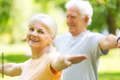 Senior Couple Exercising In Park 