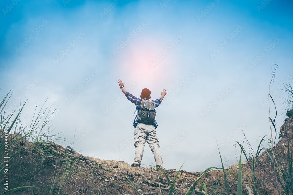 Mountain summit. Happy man gesture raised arms. Funny hiker with raised hands in the air on rock edge in national park. Vivid and strong vignetting effect. Mountain summit. Happy man gesture raised arms. Funny hiker with raised hands in the air on rock edge in national park. Vivid and strong vignetting effect.