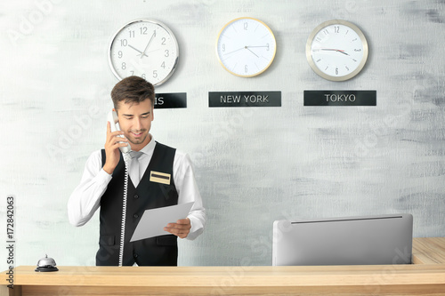 Male receptionist working i...