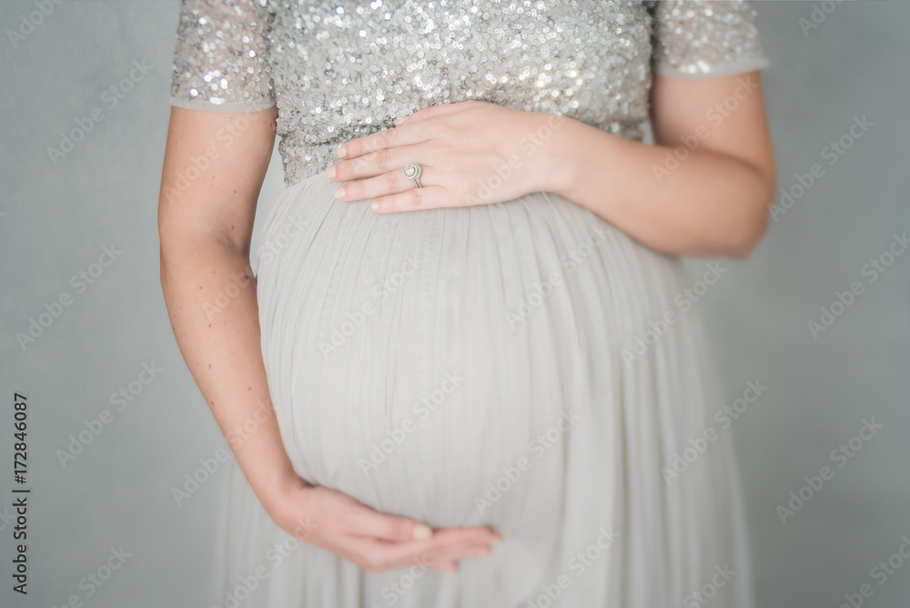 A Woman Holding Her Belly In A Sparkly Dress A Woman Holding Her Belly In A Sparkly Dress
