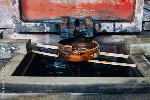 Close Up of Fresh Soy Sauce Dripping Through Wooden Sieve photo