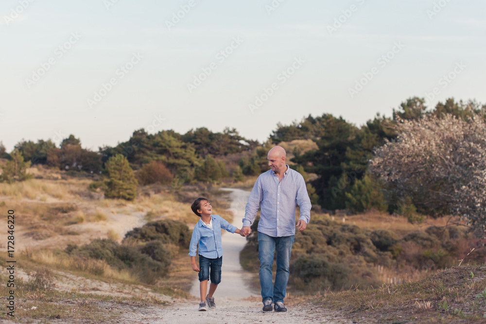 Father and son enjoying a walk in the dunes Father and son enjoying a walk in the dunes