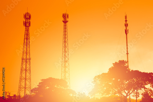 Slika na platnu silhouette multiple band telephone cellsite towers antenna on sunset dusk orange